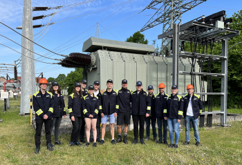 Studierendengruppe steht vor Umspannwerk