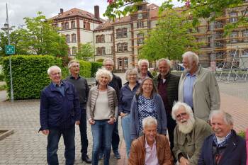 Zwöf ehemalige Studierende aus dem Jahrgang 1972 und 1973 stehen vor dem Hauptgebäude des Campus Minden.