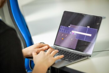 Eine Person spielt an einem Laptop das Dungeon Spiel