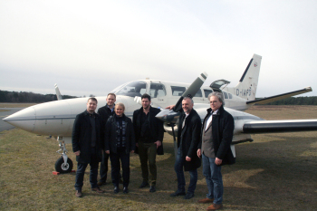 Sechs Personen vor einem Flugzeug