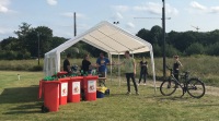 Ein Helfer holt sich an einem Pavillon Zange, Handschuhe und Müllbeutel von dem Organisationsteam