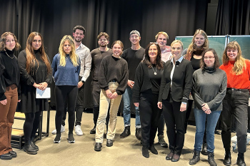 Viele Personen stehen vor einem schwarzen Vorhang im Theater der HSBI