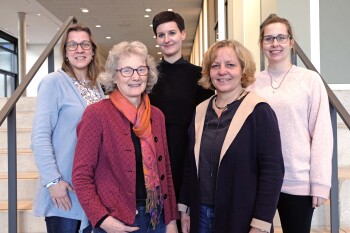 Fünf Frauen stehen in zwei Reihen auf einer Treppe