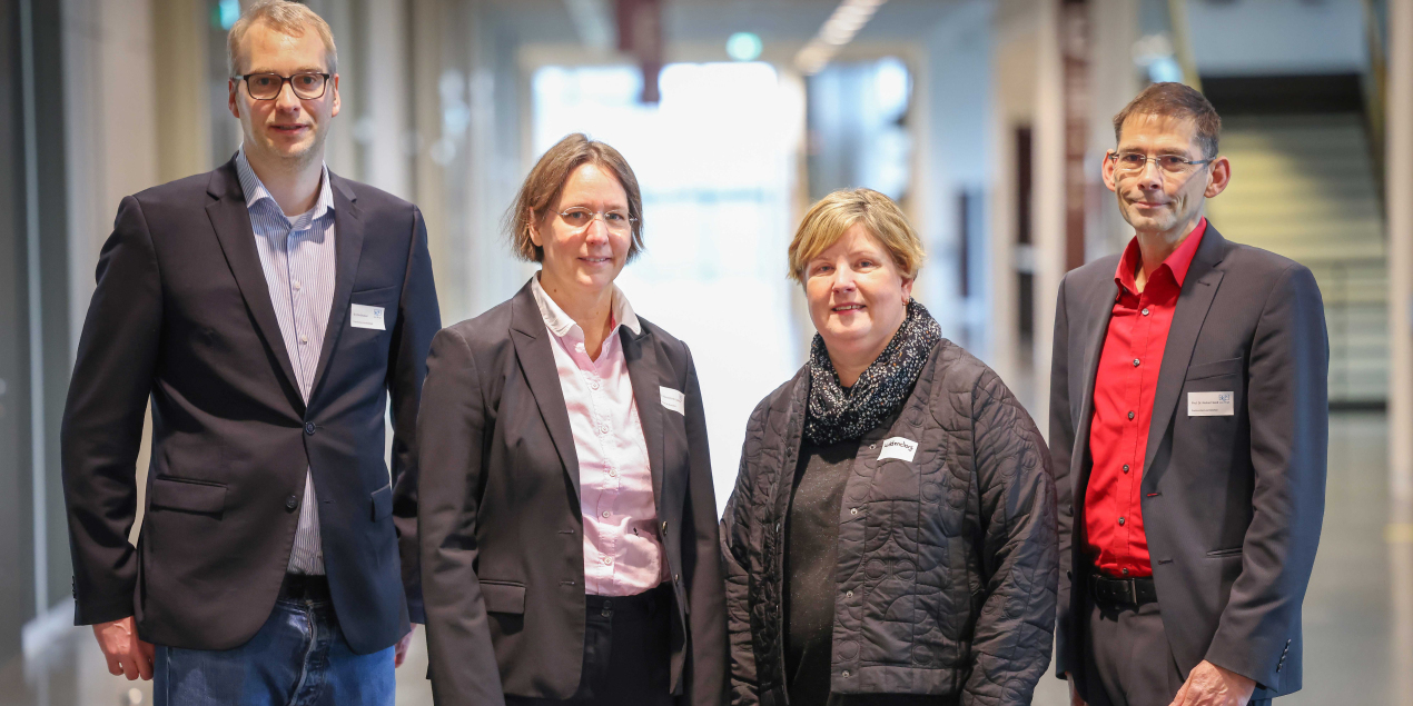 Vier Personen stehen in der Magistrale der HSBI