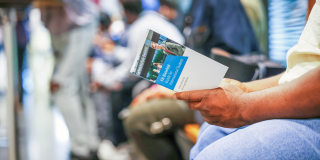 Ein Student liest einen Flyer der FH Bielefeld