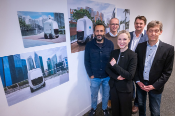 Fünf Personen stehen neben einer Wand an der Mock-ups von dem Shuttle hängen