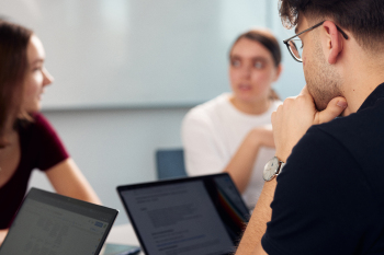 Junge Menschen sitzen an Laptops