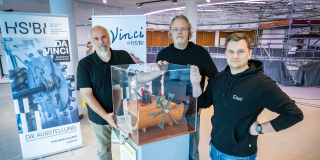 Gruppenbild des Da Vinci@HSBI Teams am Ort der Ausstellung in der neuen Wissenswerkstadt Von links nach rechts stehen ein schwarzen T Shirts oder Pullovern Andreas Wollensak, Marc Oliver Schierenberg, Andreas Born um eine Vitrine herum