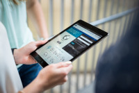 eine Person hält ein Tablet in der Hand,  das Display ist im Fokus