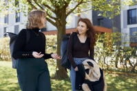 Zwei Frauen gehen im Freien nebeneinander her und unterhalten sich