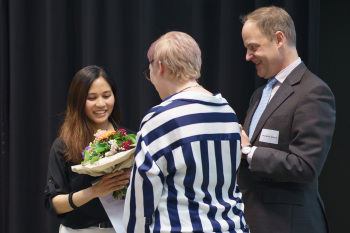 Eine Frau überrecht einen Blumenstrauß