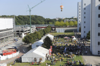 Das Bild zeigt den Blick aus einem Kranballon aus 40 metern Höhe auf das Gelände des Sommerfestes mit Zelten und vielen Gästen