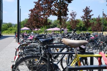 Fahrräder lehnen an Fahrradständern vor dem FH Hauptgebäude