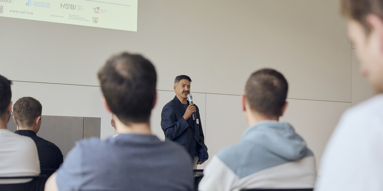 Anant Patel speaks into a microphone