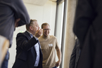 Im Konferenzsaal der HSBI sitzen die Teilnehmer:innen des Bar Camps in zwei Reihen auf Liegestühlen Unter einer Präsentation die von einem Beamer an eine Wand projiziert wird steht Professor Jens Haubrock und erklärt etwas