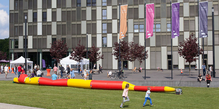 Auf dem Vorplatz der FH Bielefeld laufen viele Menschen umher