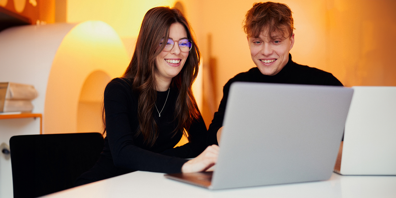 Pauline und Paul arbeiten gemeinsam an einem Laptop