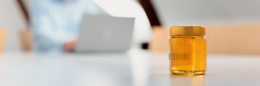 ein Glas Honig steht auf einem Besprechungstisch