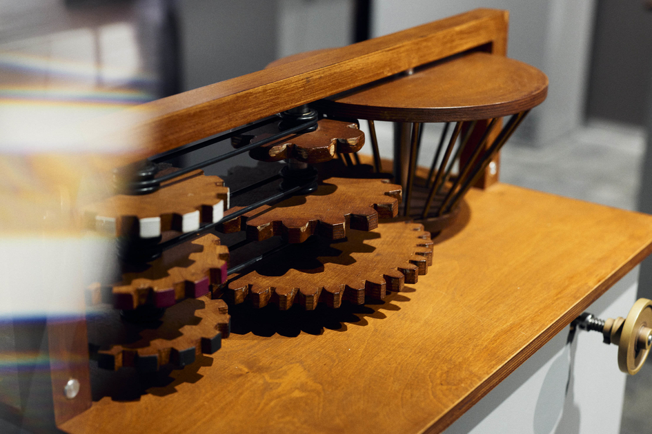 Eine Maschine aus Holz mit vielen Zahnrädern im Ausstellungsraum