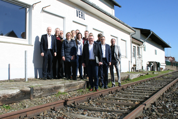 Eine Gruppe Menschen steht an einem Bahngleis