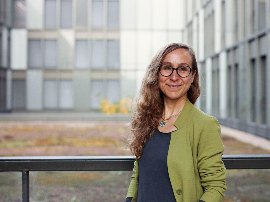 Anna Lena Rademaker steht an einer Brüstung vor dem FH Hauptgebäude