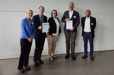 Jan Schilling and Tim Kampe holding a certificate next to Natalie Bartholomäus Sylke Fleischhut and Riza Öztürk