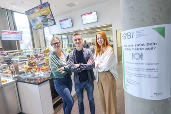 Drei Personen stehen in der Cafeteria der HSBI