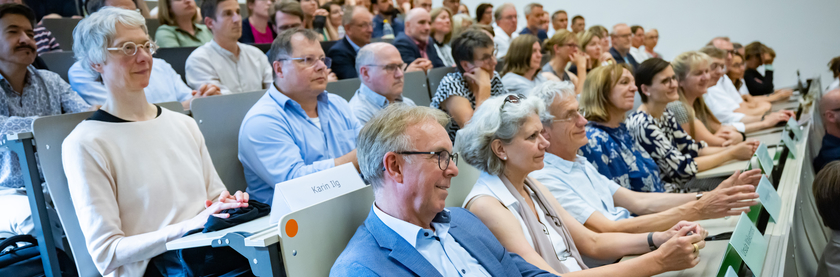 Personen sitzen in einem Hörsaal