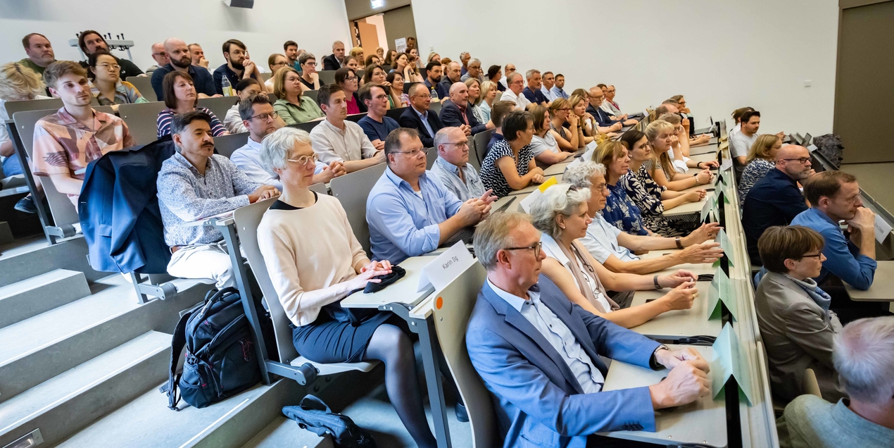 Personen sitzen in einem Hörsaal