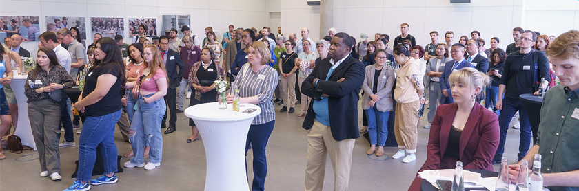 Several people stand at high tables in the conference room