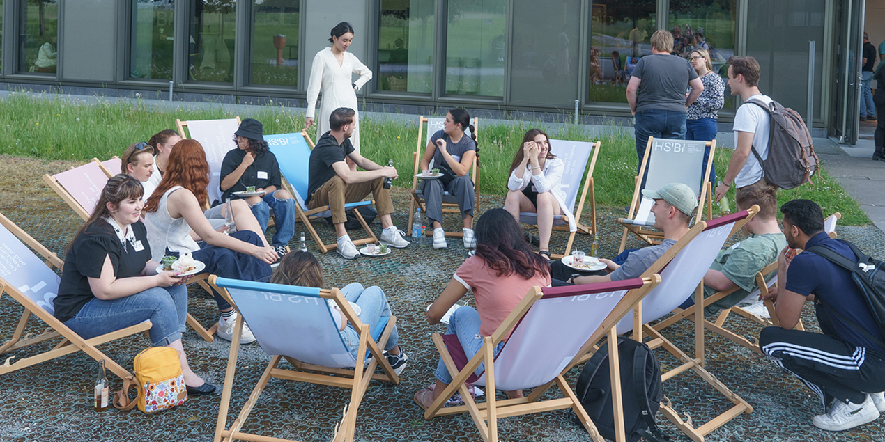 Several people sit together in deckchairs in a circle