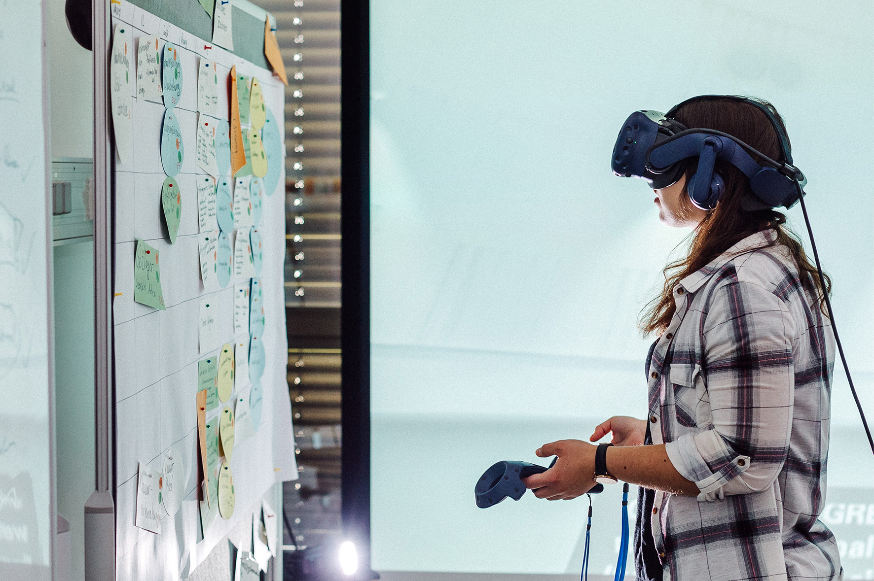 Eine Frau bewegt sich mit Hilfe einer VR-Brille im virtuellen Raum.